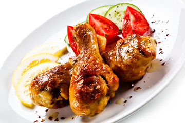 Drumsticks with vegetables on white background