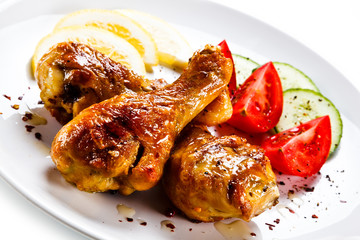 Drumsticks with vegetables on white background