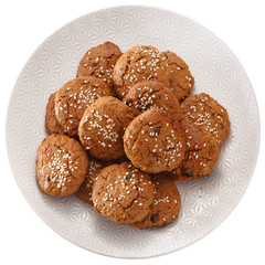 Fototapeta premium Homemade oatmeal cookies with dried berries and sesame. On a white plate. View from above. Isolated on white background.