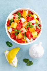 Healthy vegetarian fresh fruit salad with apple, pear, tangerine, grapefruit, mango, pomegranate and lemon juice