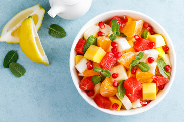 Healthy vegetarian fresh fruit salad with apple, pear, tangerine, grapefruit, mango, pomegranate and lemon juice