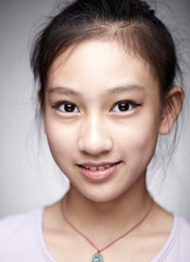 Close-up portrait of cute Asian Chinese little girl indoors against white background