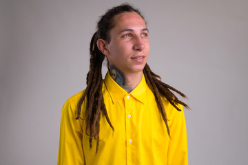 Fototapeta premium Face of young happy businessman with dreadlocks thinking