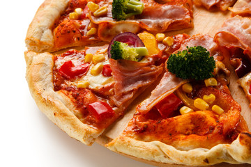 Pizza with bacon and vegetables on cutting board on white background