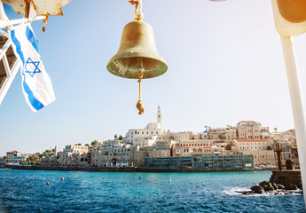 Ancient city ashore sea to Israel. Ship's bell on the background.