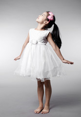 Fototapeta premium Cute Asian Chinese little girl indoors against white background
