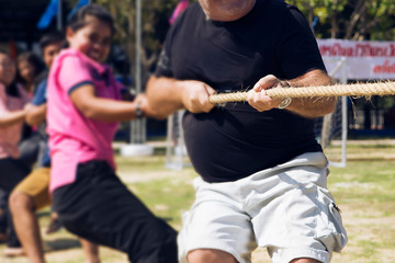 The hand of the contestant tugs the force to pull for victory.