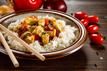 Grilled meat, white rice and vegetables on wooden table