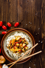 Grilled meat, white rice and vegetables on wooden table