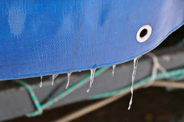 Plastic cloth with icicles. Waterproof surface. Blue tarpaulin.