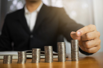 Businessman picks coins on the table, counts money . Business concept.