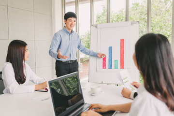 Asian man give a presentation to team