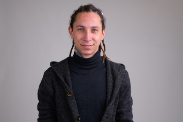 Portrait of happy young handsome man with dreadlocks smiling