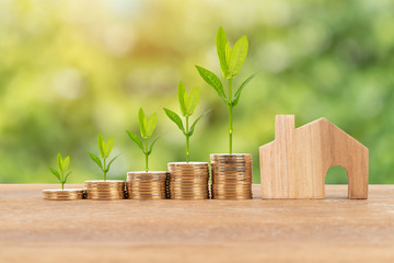 Model house and coin stack on white background mortgage saving concept