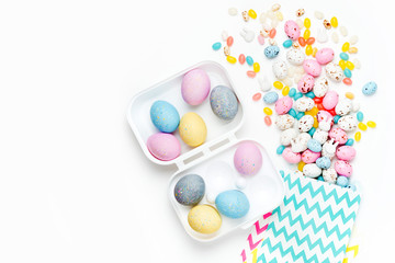 Fototapeta na wymiar Easter candy chocolate eggs and Jellybean flowing from party paper bag on white background