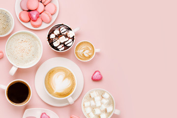 Various kinds of coffee in cups of different size with candys and macaroons on pale pink background.  Coffee  Time concept.  Flat lay, top view