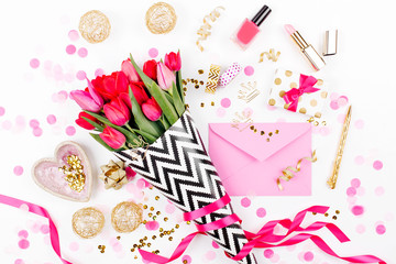 Pink and Gold Styled Desk with Florals. Pink tulips in black and white stylish wrapping paper, gifts, cosmetics and female accessories with confetti on white background