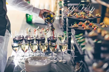 Foto op Plexiglas The waiter pours wine into glasses. Event catering concept. © Mr. Music