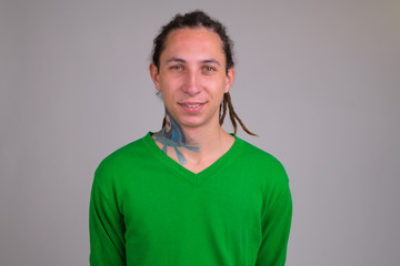 Obraz premium Portrait of happy young handsome man with dreadlocks smiling