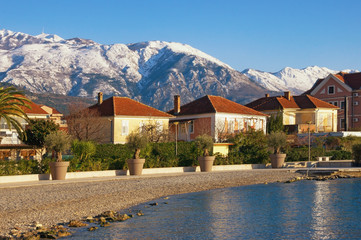 Green town at the foot of the snowy mountains.  Montenegro, Bay of Kotor, view of embankment of...