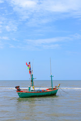 Naklejka na ściany i meble Traditional fishing boat tied with rope in sea near beach