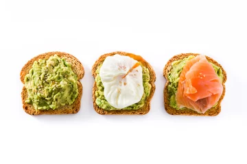 Schilderijen op glas Toasted breads with avocado, poached eggs and salmon isolated on white background. Top view. © chandlervid85