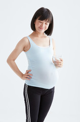 Asian pregnant woman drinking water,white background in studio