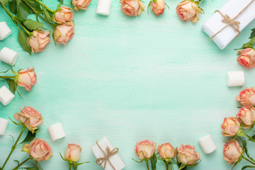 Pink roses on mint wooden background with gifts, festive background, anniversary, wedding, Valentine's Day.Flat lay.top view, copy space