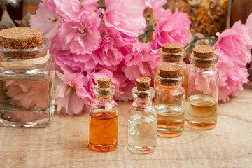 Bottles of essential oil with pink kwanzan cherry blossoms