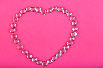 Obraz premium Beaded heart on a pink background Horizontal