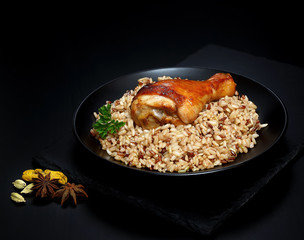 grilled chicken leg with wild rice on a black background