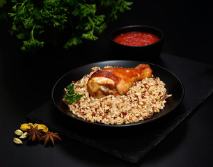grilled chicken leg with wild rice on a black background