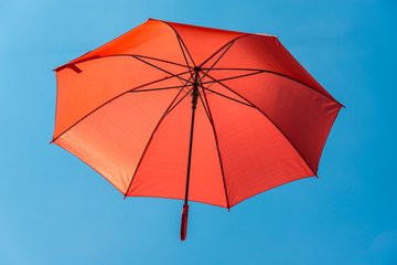 Roter Regenschirm im blauen Himmel