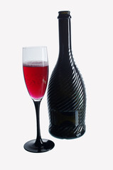 A glass of red champagne and a bottle on white. Isolated on white