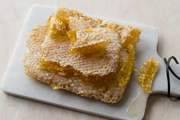 Fresh Honeycomb Slices with Honey on Marble Board.