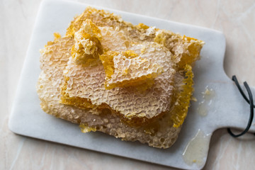 Fresh Honeycomb Slices with Honey on Marble Board.