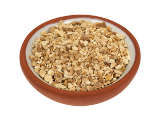 Cut orris root in a small bowl on a white background