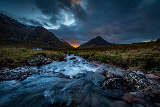 Small stream in the foreground with summit of Stob Coire and Stob Na Doire in the background at sunset, Glen Coe, west Highlands, Scotland, United Kingdom, Europe