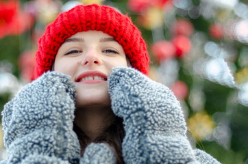Outdoor portrait of elegant brunette woman wearing stylish red cap and warm coat. Space for text