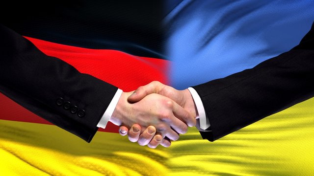 Germany and Ukraine handshake international friendship relations flag background - Powered by Adobe