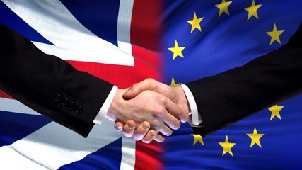 Great Britain and EU handshake international friendship summit, flag background