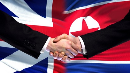 Great Britain and North Korea handshake international friendship flag background