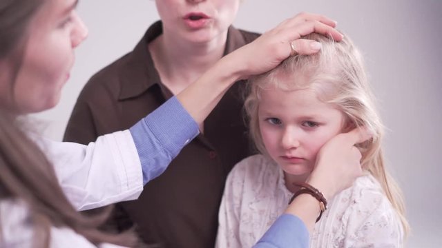 doctor is palpating lymph node on the neck of 5 years old girl, medical checkup