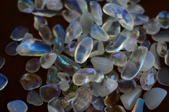 Beautiful, bright tumbled crystal chips. Stunning healing crystals. Macro photograph, low exposure. Hand holding crystals, bright healing crystals. Crisp colors and lighting, clear quartz, opalite