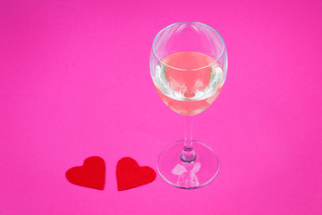 Glass and red paper forms of heart for Valentine's Day