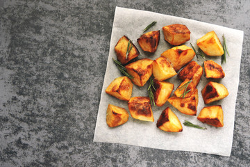 Baked potatoes on paper with rosemary and sea salt. Top view.