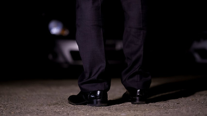 Man standing in front of car on parking, going to nightclub party, entertainment