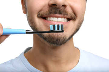 Young man with toothbrush on white background, closeup