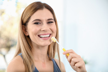 Portrait of woman with toothbrush on blurred background, space for text. Personal hygiene