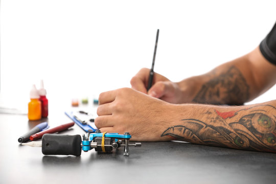 Professional Tattoo Artist Drawing Sketch At Table Indoors